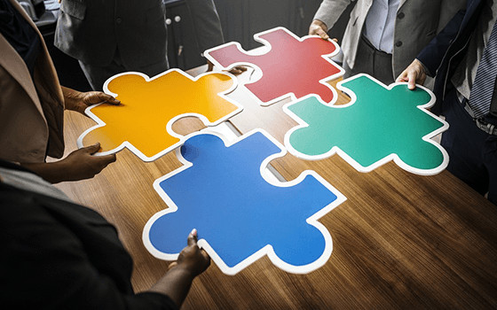 Four large puzzle pieces being put together on a table