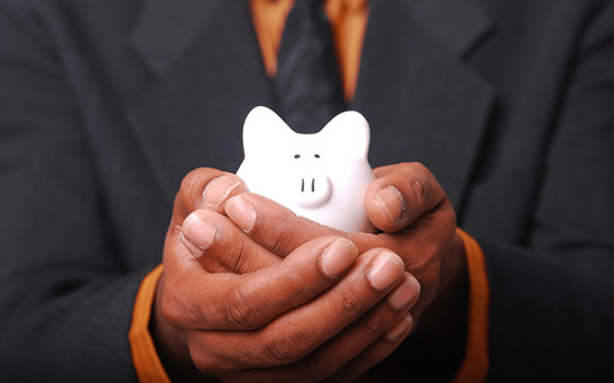 A person's hands holding a small piggy bank